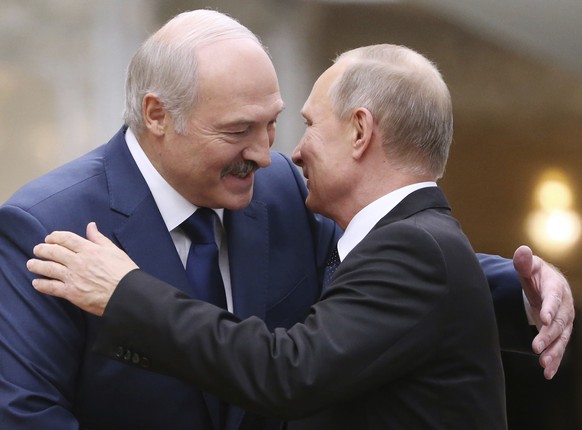 ARCHIV - 30.11.2017, Belarus, Minsk: Alexander Lukaschenko (l), Pr�sident von Belarus, begr��t den russischen Pr�sidenten Wladimir Putin w�hrend des Gipfeltreffens des Kollektiven Sicherheitsrats der  ...