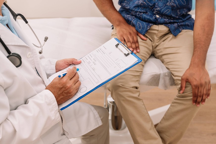 Crop doctor writing information on clipboard Unrecognizable male doctor in medical uniform taking notes on paper using clipboard near anonymous patient in hospital MR RenataHamuda_ID16022_487913_034 C ...