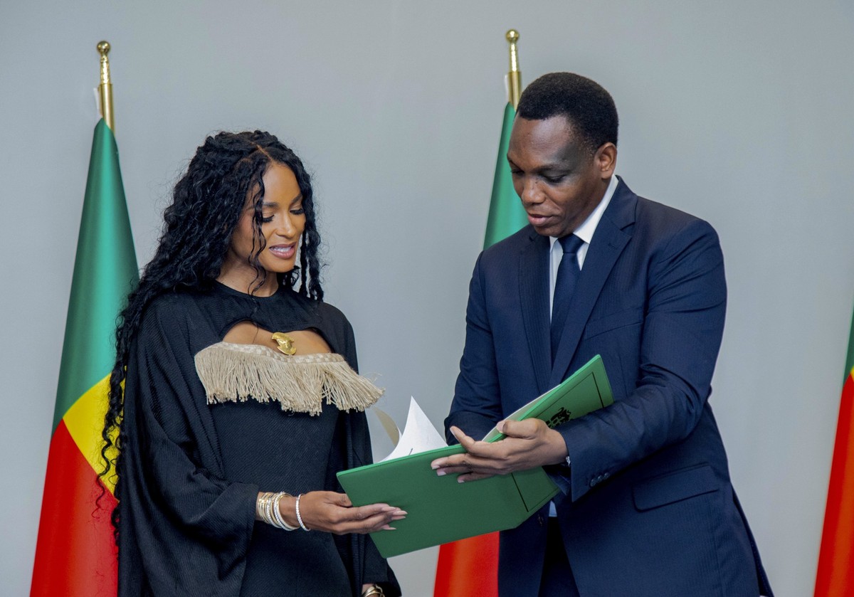 Yvon Detchenou, Benin&#039;s Minister of Justice and Legislation, right, presents citizenship documents to singer Ciara at a ceremony in Cotonou, Benin, Saturday July 26, 2025.(AP Photo/Via Benin Pres ...