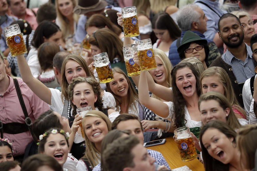 Young people celebrate the opening of the 185th 'Oktoberfest' beer festival in Munich, Germany, Saturday, Sept. 22, 2018. The world's largest beer festival will be held from Sept. 22 until Oct. 7, 201 ...