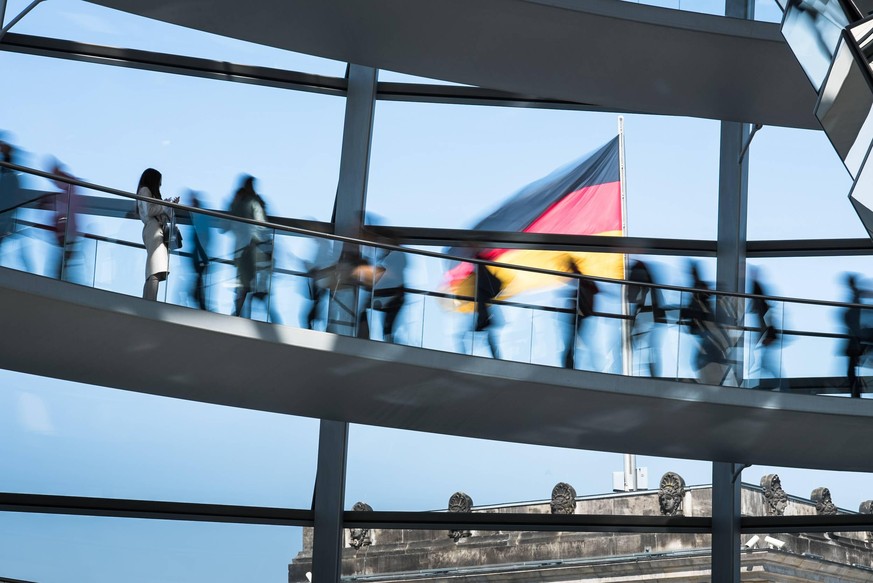 Regierungsviertel Das Innere der Reichstagskuppel in einer Langzeitbelichtung. Reichstagskuppel; Besucher; Wandelgang; Rampe; Langzeitbelichtung; Deutschlandfahne; Blauer Himmel; Tourismus; Touristen; ...