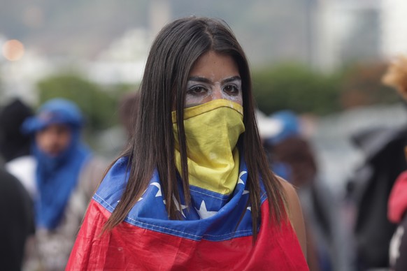 Demonstrantin in Caracas: Ihr Gesicht hat die junge Frau mit der venezolanischen Flagge umwickelt, um die Augen hat sie Zahnpasta geschmiert, um die Wirkung des Tränengases zu mindern.