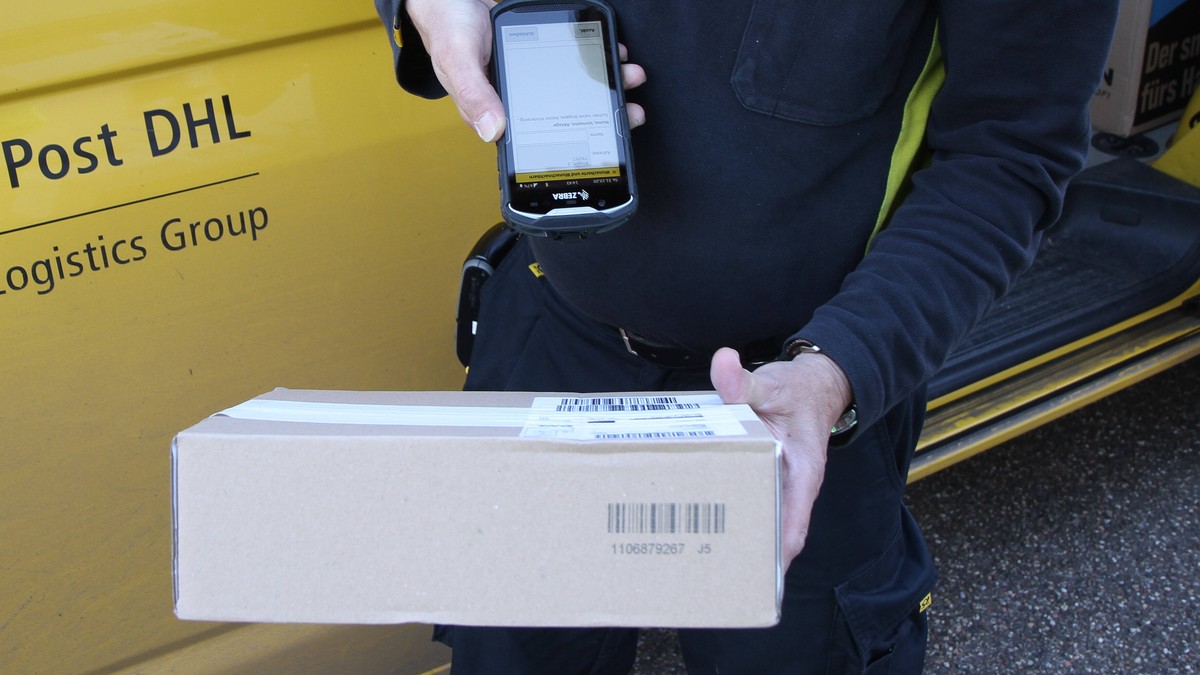 Winden Themenbild - Deutsche Post, DHL, Brieftraeger, Postbote Themenbild - Deutsche Post, DHL, Brieftraeger, Postbote 31.10.2020 Brieftraeger beim Post austragen und Paket scannen, Paket ausliefern,  ...