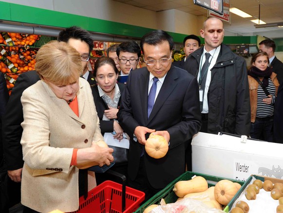 Chinese Premier Li Keqiang (C) and German Chancellor Angela Merkel (L) visit a supermarket after the bilateral governmental consultations in Berlin, Germany, Oct. 10, 2014. ) (ry) GERMANY-BERLIN-CHINA ...