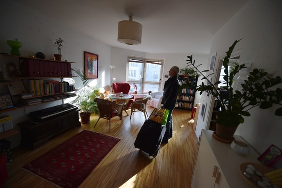 ARCHIV - 07.11.2014, Berlin: ILLUSTRATION - Ein Tourist, der eine Übernachtung über das Onlineportal Airbnb gebucht hat, kommt mit seinem Koffer in der gemieteten Wohnung an. (zu dpa «Aufgestaute Reis ...