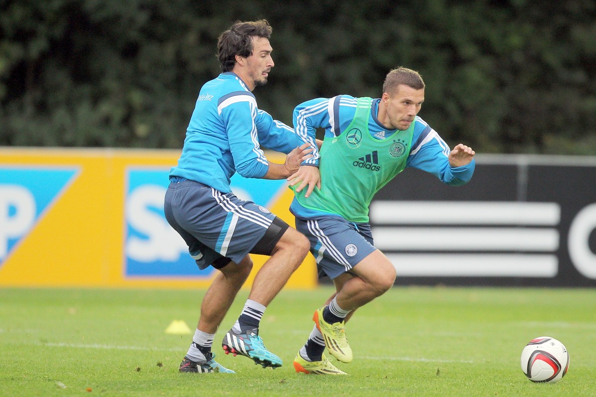 ARCHIV - 06.10.2014, Hessen, Frankfurt/Main: Lukas Podolski (r) und Mats Hummels kämpfen am 07.10.2014 beim Training der deutschen Fußball-Nationalmannschaft auf dem Trainingsplatz &quot;Kleine Kampfb ...