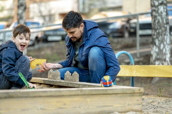 Father and son building sandcastle at park model released, Symbolfoto, ANAF01379