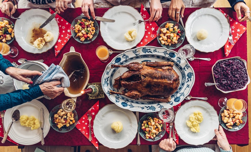 woman holding antique gravy boat for christmas roast on festive decorated table