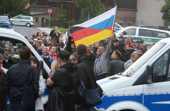 Vor dem Asylbewerberheim in Freital bei Dresden ist es am Mittwochabend (24.06.15)erneut zu Protesten gekommen (Foto: Asylkritiker halten eine deutsch-russische Fahne hoch). Den dritten Tag in Folge d ...