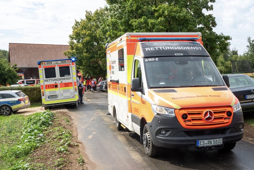 12.08.2023, Baden-Württemberg, Unterensingen: Rettungsdienste stehen nahe der Unglücksstelle. Beim Einschlag eines Blitzes in einen Baum sind sechs Menschen verletzt worden, drei davon lebensgefährlic ...