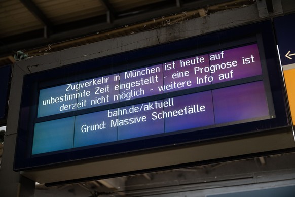 02.12.2023, Bayern, München: Ein Schild weist am Hauptbahnhof auf den eingestellten Zugverkehr im Großraum München hin. Der Zugverkehr von und zum Hauptbahnhof wurde vorübergehend eingestellt. Schnee  ...