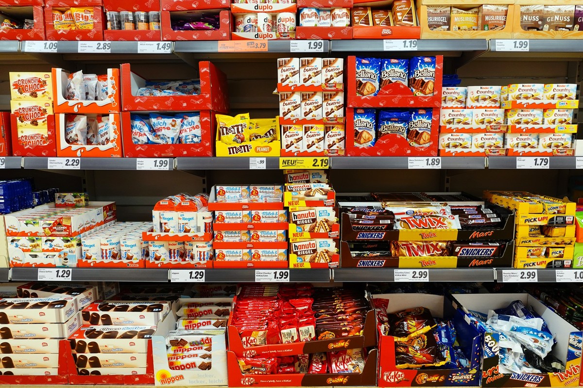Confectionery aisle of a Supermarket, GERMANY - DECEMBER 2019: Assortment of different brands Candy bars in boxes on shelves in a Lidl discount supermarket.
