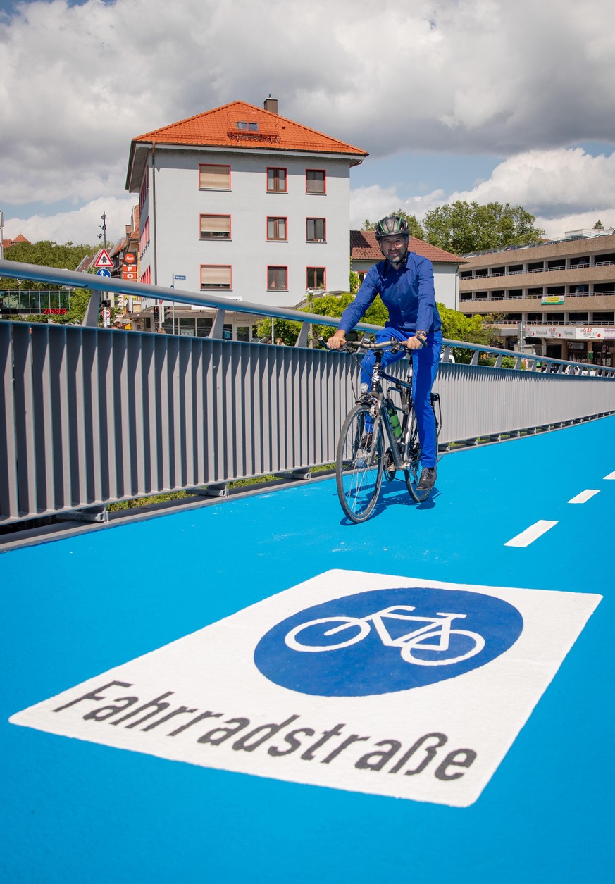Boris Palmer, Oberbürgermeister von Tübingen, fährt mit seinem Fahrrad über eine beheizbare Radbrücke, die er kurz zuvor eröffnet hatte.