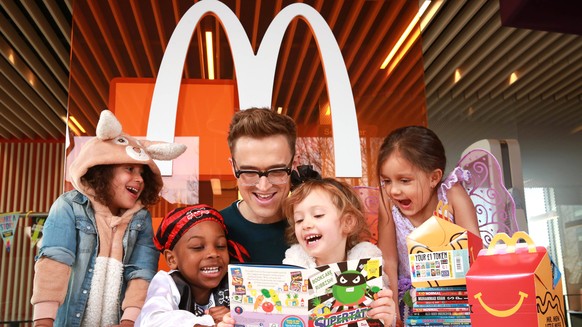 World Book Day EDITORIAL USE ONLY Children s author and musician Tom Fletcher reads to left to right four year olds Pearl Prasad, Zane-Ellis Yeboah, Maisie Patey, and five year old Alexandra Ancharaz, ...