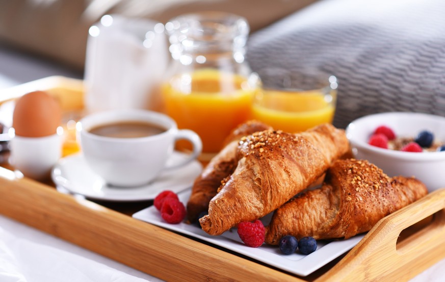 A tray with breakfast on a bed in a hotel room, A tray with breakfast on a bed in a hotel room., A tray with breakfast on a bed in a hotel room., 02.04.2023, Copyright: xmonticellox Panthermedia340508 ...