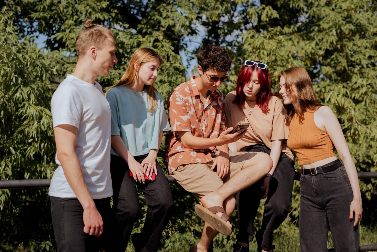 Teen group watching smartphone content in sunny park Homie, Gomel Region, Belarus CR_NAJJ250414-1701763-01 ,model released, Symbolfoto