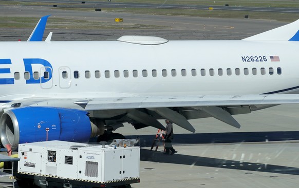 15.03.2024, USA, Medford: Ein Mitarbeiter des Medford Jet Centers geht unter einer Boeing 737-824 von United Airlines, die auf dem Rogue Valley International-Medford Airport aus San Francisco gelandet ...