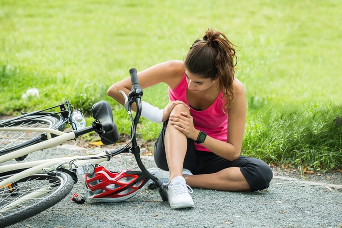 Young Woman With Pain In Knee When Fallen Down From Bicycle