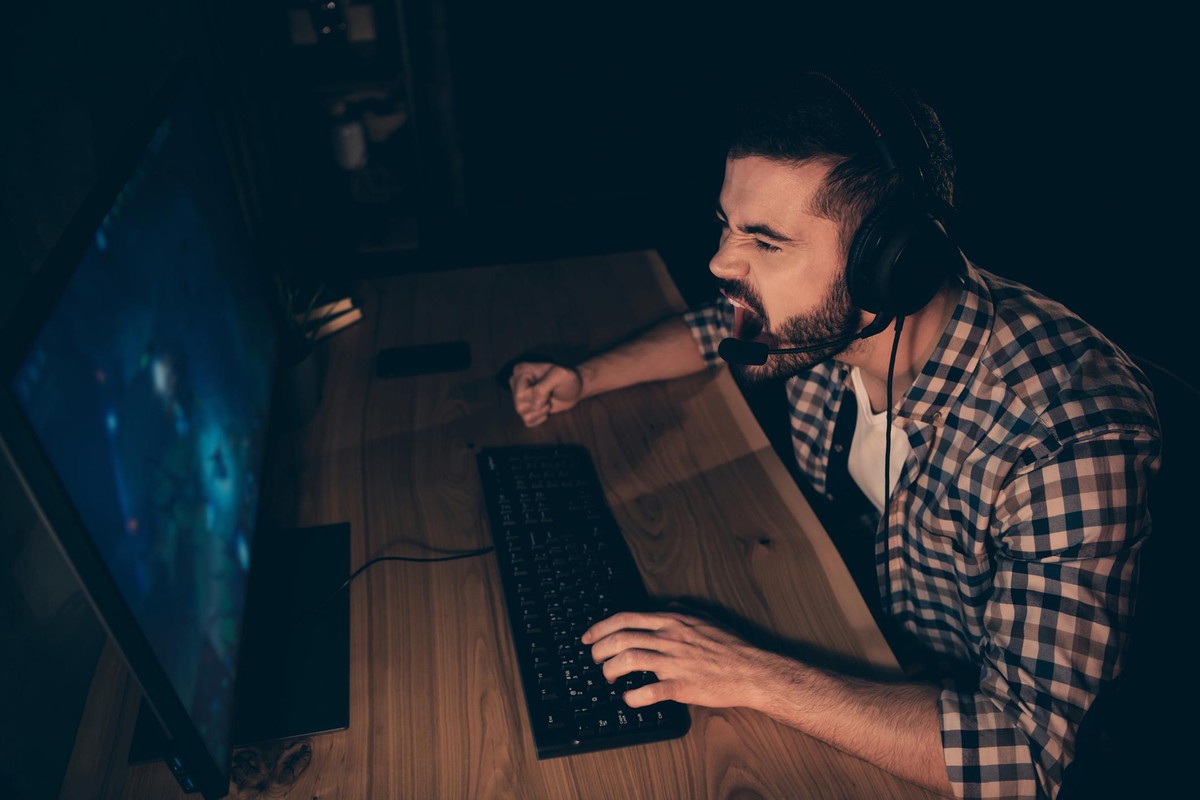 Close up side profile photo professional he him his anger rage outraged guy play, videogame challenge tournament talk teammates headset wear casual plaid checkered shirt internet user house indoors
