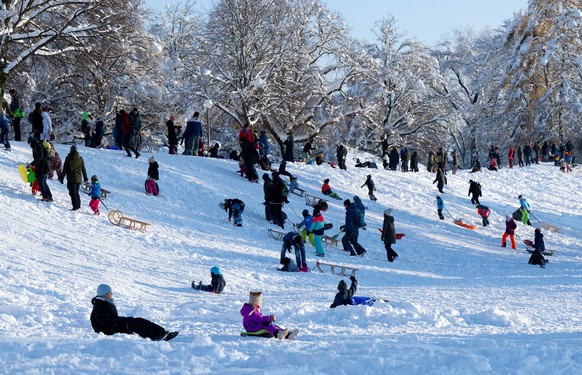 03.12.2023, Bayern, M�nchen: Zahlreiche Menschen nutzen das sch�ne Wetter im Olympiapark f�r einen Spaziergang oder eine Schlittenfahrt. Schnee und Eis haben im S�den Bayerns auf den Stra�en und bei d ...