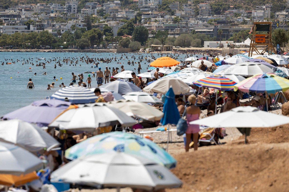 14.07.2024, Griechenland, Athen: Blick auf einen vollen Strand im Vorort Varkiza, südlich von Athen. Die griechischen Behörden haben vor einer drohenden einwöchigen Hitzewelle während der Sommerreisez ...