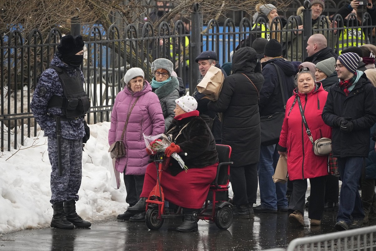 01.03.2024, Russland, Moskau: Ein Polizist bewacht die Menschen, die sich an der Kirche zu Ehren der Gottesmutterikone «Lindere meine Trauer» im südöstlichen Bezirk Marjino vor der Beerdigung des Krem ...
