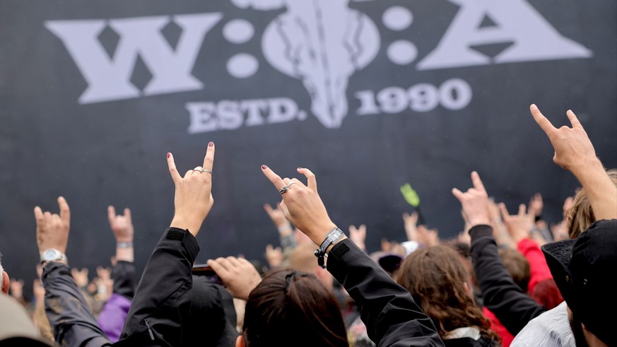 02.08.2023, Schleswig-Holstein, Wacken: Metal-Fans feiern nach der Öffnung des sogenannten «Infield» vor der «Faster-Stage», einer der beiden Hauptbühnen auf dem Festivalgelände. Das Wacken Open-Air ( ...
