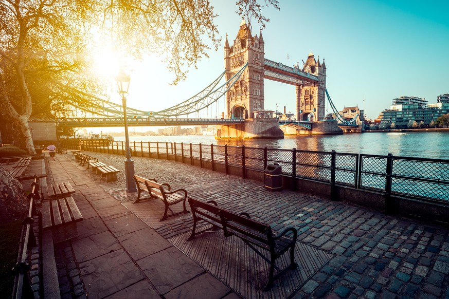 A boulevard next to the river Thames with Tower Bridge in the distance