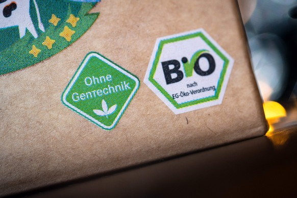 ARCHIV - 04.10.2022, Bremen: Das Logo �Ohne Gentechnik� und das Bio-Siegel &quot;Bio nach EU-�ko-Verordnung&quot; sind auf einer Lebensmittelverpackung zu sehen. Die EU-Kommission stellt am Mittwoch ( ...