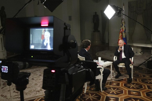 In this photo released by Sputnik news agency on Friday, Feb. 9, 2024, Russian President Vladimir Putin, right, gestures as he speaks during an interview with former Fox News host Tucker Carlson, back ...