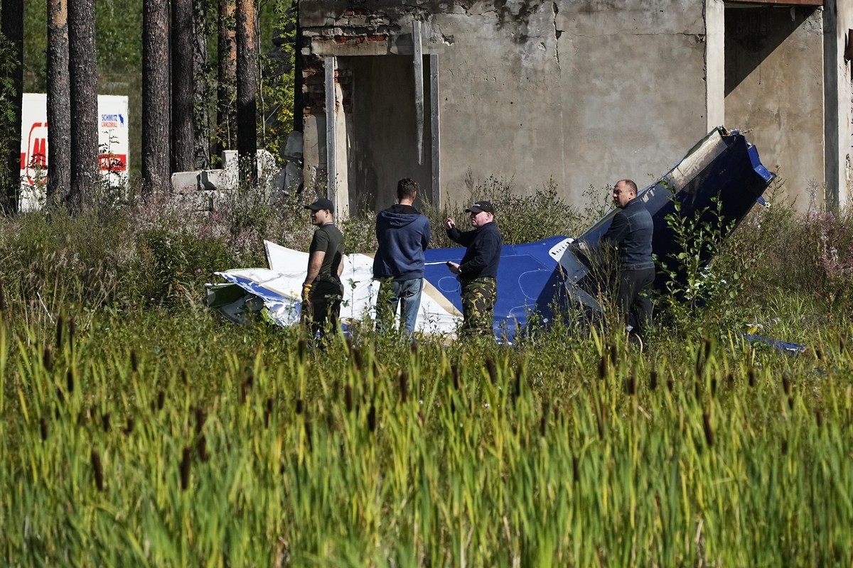 24.08.2023, Russland, Kushenkino: Russische Soldaten inspizieren ein Teil eines abgestürzten Privatjets. Der russische Söldnerführer Jewgeni Prigoschin ist nach Angaben seines Telegram-Kanals Grey Zon ...
