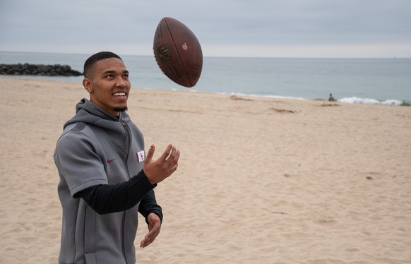 ARCHIV - 09.02.2021, USA, Newport Beach: Amon-Ra St. Brown f�ngt einen Football am Strand. (zu dpa: �St. Brown �ber Lions-Siegesserie: Spielen einfach besser zusammen�) Foto: Maximilian Haupt/dpa +++  ...