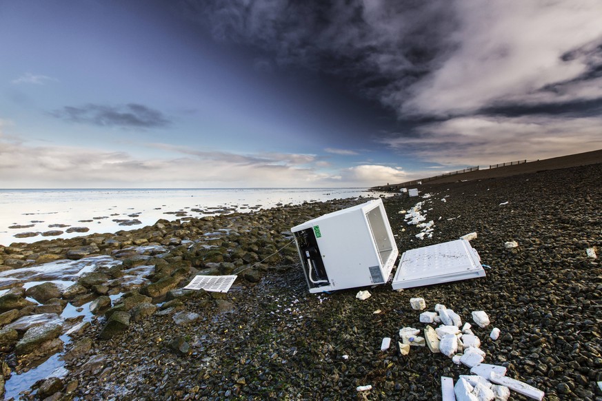 angeschwemmter Kuehlschrank im Watt nach dem Verlust von Containern der MSC Zoe in Sturm auf der Nordsee, Niederlande, Friesland, Wierum washed up freezer in the wadden sea after lost of a container p ...