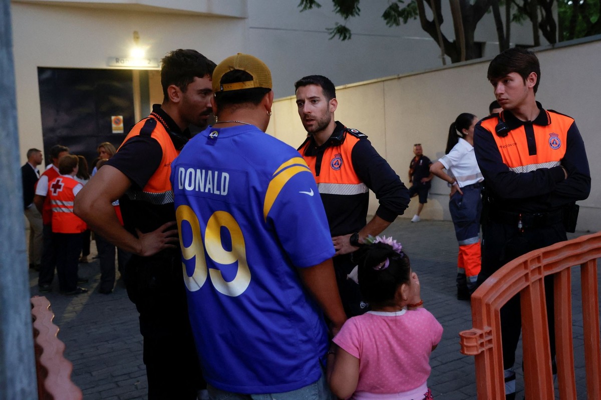 A man speaks with members of civil services in the aftermath of fire in nightclubs in Murcia, Spain, October 1, 2023. REUTERS/Eva Manez