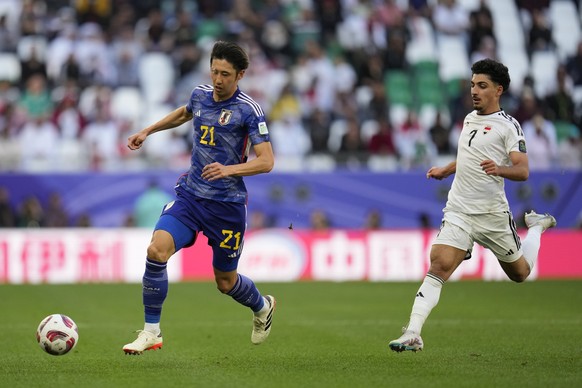 Japan&#039;s Hiroki Ito, left, and Iraq&#039;s Youssef Wali Amyn run for the ball during the Asian Cup Group C soccer match between Iraq and Japan at the Education City Stadium in Al Rayyan, Qatar, Fr ...