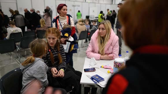 Oksana (r) aus Saporischschja und Lubmila (stehend) aus Odessa warten mit ihren Kindern im Ankunftszentrum Dresden für geflüchtete Menschen aus der Ukraine in der Messe. In dem Ankunftszentrum bekomme ...