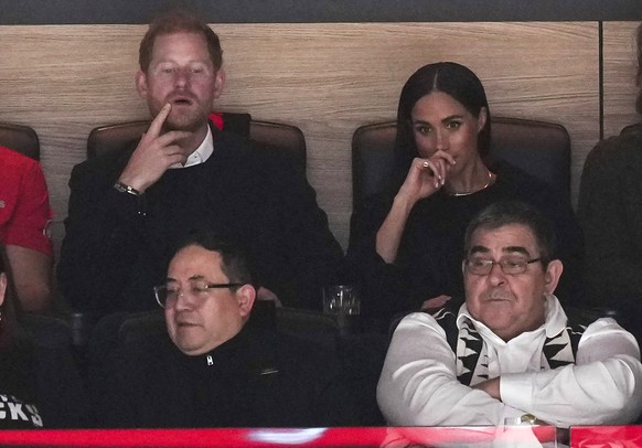 Prince Harry, top left, and Meghan Markle, top right, The Duke and Duchess of Sussex, watch the Vancouver Canucks and the San Jose Sharks play during the first period of an NHL hockey game in Vancouve ...