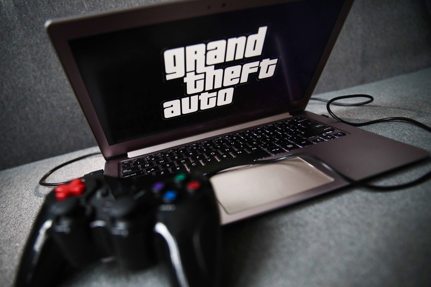 Video Games Brands Photo Illustrations Grand Theft Auto logo displayed on a laptop screen and a gamepad are seen in this illustration photo taken in Krakow, Poland on September 21, 2021. Krakow Poland ...
