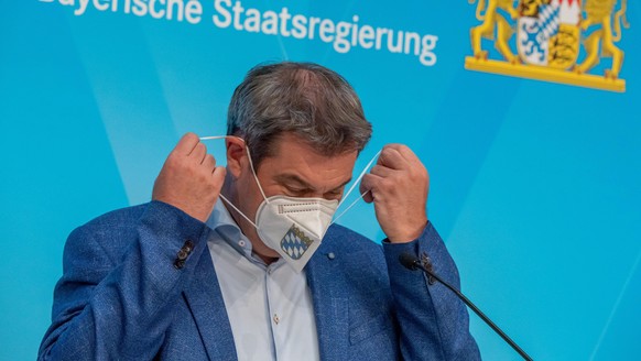 04.06.2021, Bayern, München: Markus Söder (CSU), Ministerpräsident von Bayern, nimmt auf einer Pressekonferenz nach der Kabinettssitzung der bayerischen Staatsregierung seine FFP-2-Maske ab. Foto: Pet ...