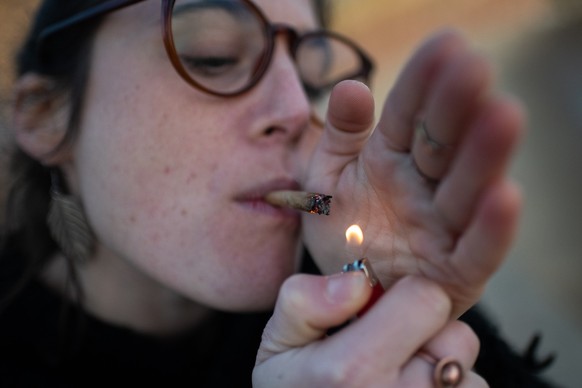 PRODUKTION - 05.09.2023, Uruguay, Montevideo: Eine junge Frau raucht einen Cannabis-Joint auf der Rambla. In Uruguay gibt es das Rauschmittel längst legal in Apotheken. (zu dpa-KORR Cannabis vom Olymp ...