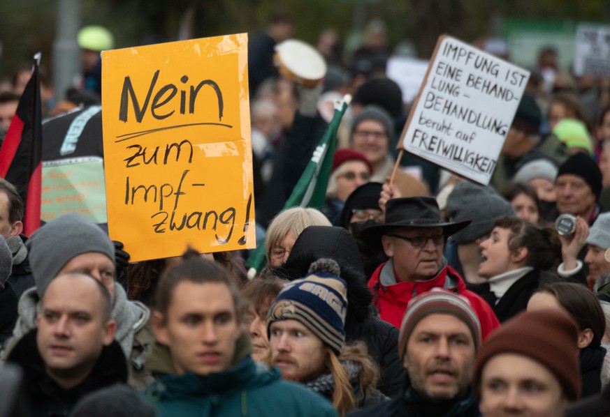 27.11.2021, Hessen, Frankfurt/Main: Teilnehmer einer Demonstration halten ein Plakat mit der Aufschrift &quot;Nein zum Impfzwang!&quot;. Mehr als zweitausend Impfgegner, Coronaleugner und Querdenker d ...