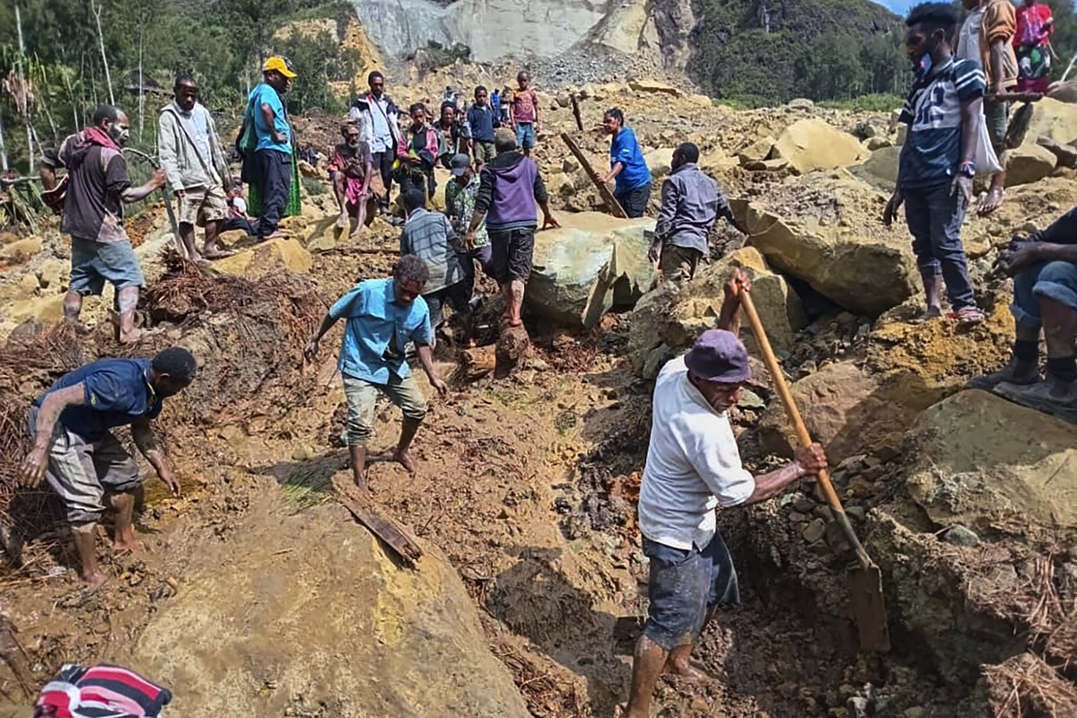 26.05.2024, Papua-Neuguinea, Yambali: Auf diesem von der Internationalen Organisation für Migration via AP zur Verfügung gestellten Foto suchen Dorfbewohner nach einem Erdrutsch im Dorf Yambali nach V ...