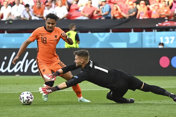 Donyell Malen of the Netherlands, left, challenges for the ball with Czech Republic's goalkeeper Tomas Vaclik during the Euro 2020 soccer championship round of 16 match between the Netherlands and Cze ...