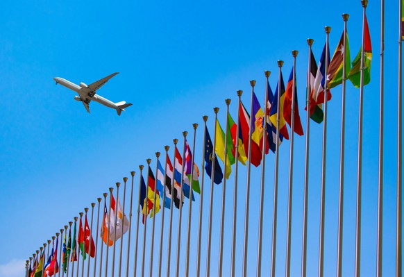 airplane flying over the national flags