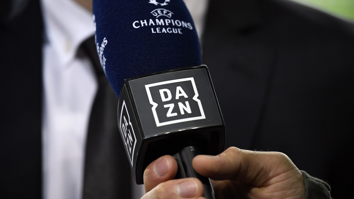 ARCHIV - 28.11.2018, Portugal, Porto: Ein Reporter hält ein Mikrofon des Streamingdienstes DAZN während eines Interviews fest. Der Internet-Anbieter DAZN hat sich das größte Rechtepaket an der Fußball ...