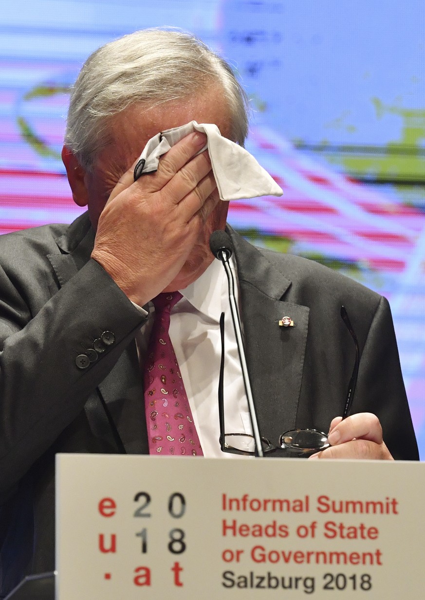 Jean-Claude Juncker, President of the European Commission, wipes his face during a press conference after the informal EU summit in Salzburg, Austria, Thursday, Sept. 20, 2018. (AP Photo/Kerstin Joens ...