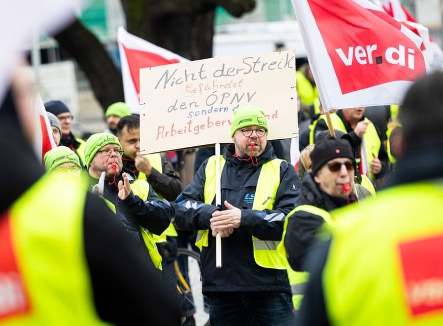 02.02.2024, Niedersachsen, Hannover: Ein Teilnehmer einer Verdi-Demonstration steht mit einem Schild mit der Aufschrift «Nicht der Streik gefährdet den PNV, sondern der Arbeitgeberverband» während ein ...