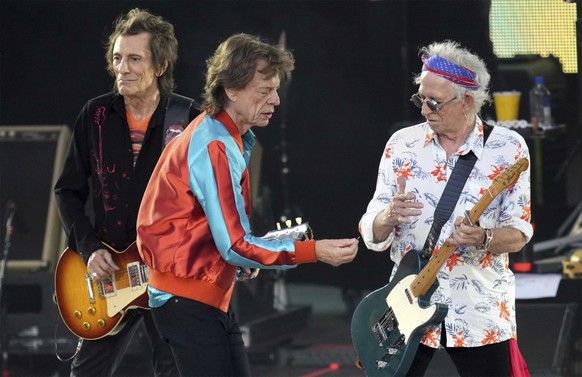 Mick Jagger, center, singer of the band &#039;The Rolling Stones&#039;, hands over a new plectrum to guitarist Keith Richards, right, during the last concert of the &#039;Sixty&#039; European tour in  ...