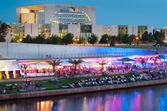 One of the most popular beach bars in Berlin on the banks of the Spree. In the background, the German Chancellery.