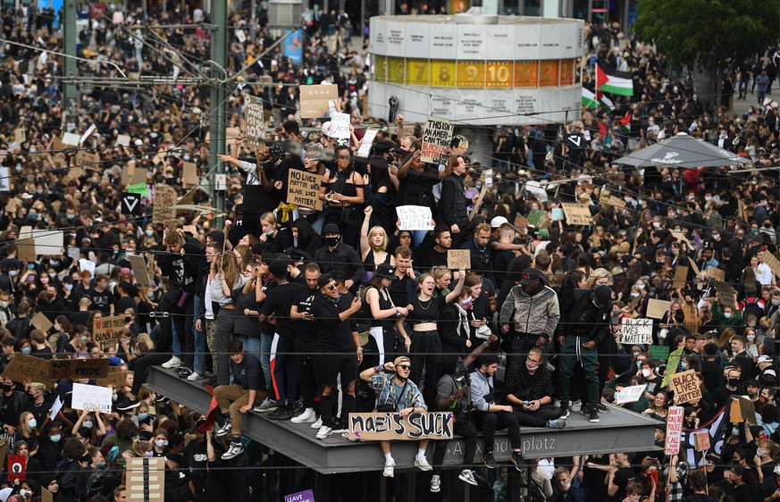 06.06.2020, Berlin: Teilnehmer einer Kundgebung protestieren auf dem Alexanderplatz gegen Rassismus und Polizeigewalt. Anlass der landesweiten Proteste ist der gewaltsame Tod von George Floyd am 25. M ...